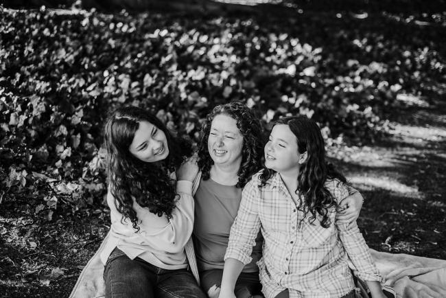 perthfamilyphotographer Black and white image of mother and her two daughters laughing during a family photography session at Hyde Park, Perth