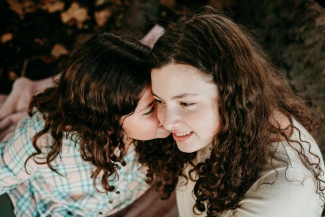 20180520-DSC_5572 Sister kissing her older sister during a family photography session at Hyde Park, Perth
