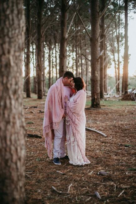 20180614-DSC_9752 Man and woman wrapped in a pink blanket and cuddling together during a golden hour maternity photography session at The Pines Wanneroo in Perth
