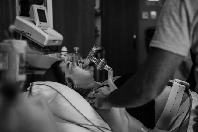 Black and white image of a labouring mother using gas during a Perth birth photography session