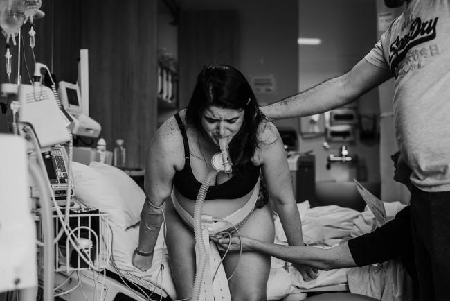Black and white image of a pregnant woman in labour using gas during a Perth birth photography session