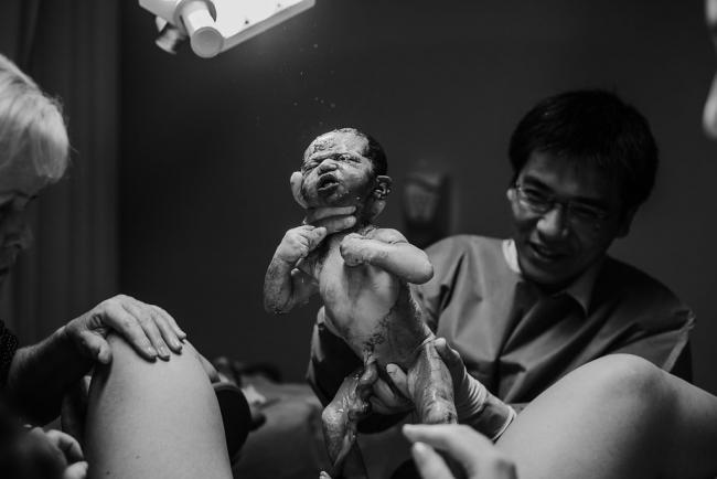 Black and white image of baby being born during a Perth birth photography session