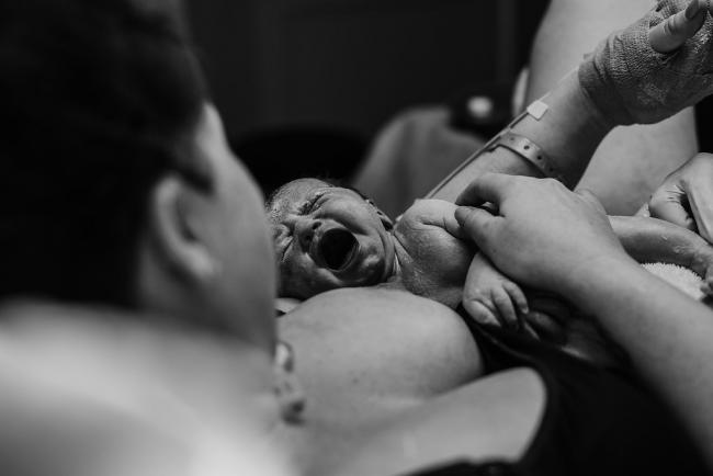 Black and white image of a new baby's first cry during a Perth birth photography session