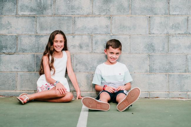 Siblings sit against wall during family photography Perth session