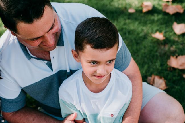 Son sitting in fathers lap during family photography Perth session