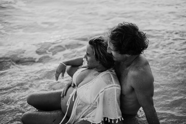 20180505-20180505-DSC_2928-2 Black and white image of couple sitting in the water during maternity photography Perth session at Burns Beach