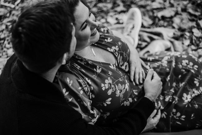 20180609-20180609-DSC_6587 black and white image of couple sitting and holding tummy during maternity photography Perth session at John Oldham Park