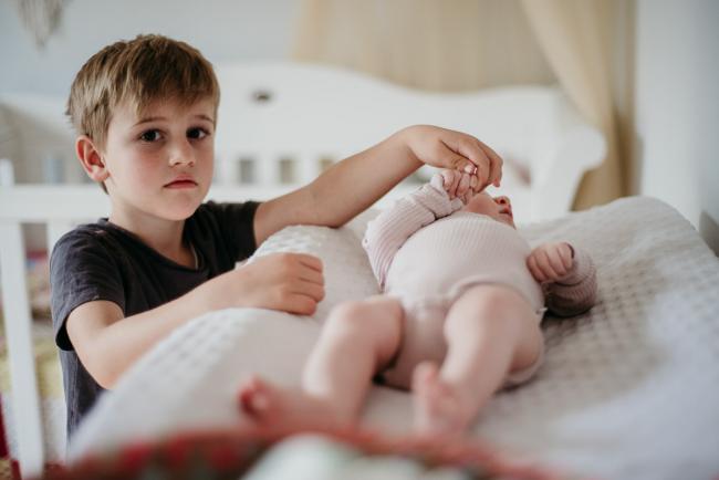20180610-20180610-DSC_8503 little boy touching his baby sister's hand on the change table during lifestyle newborn photography Perth session
