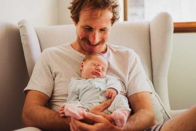 20180615-DSC_0267 Father smiling and holding his new baby during lifestyle newborn photography Perth session