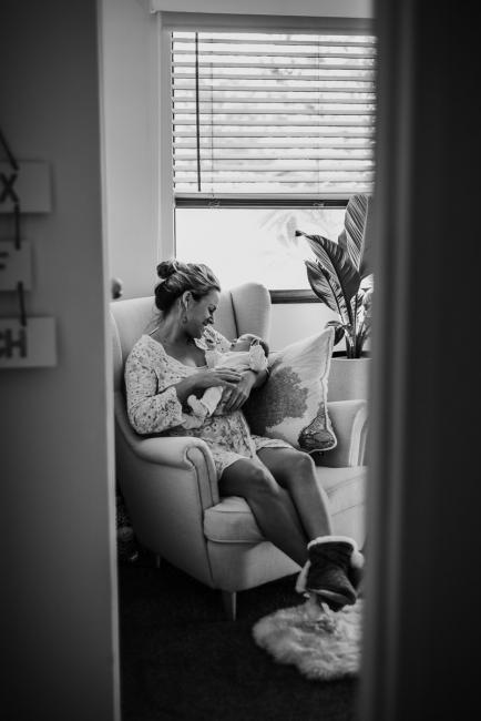 20180615-DSC_0384 Black and white image of mother holding new baby on feeding chair during lifestyle newborn photography Perth session