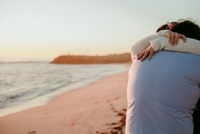 20180616-20180616-DSC_1396 Woman's hands wrapped around mans's neck in embrace during maternity photography Perth session at Burns Beach