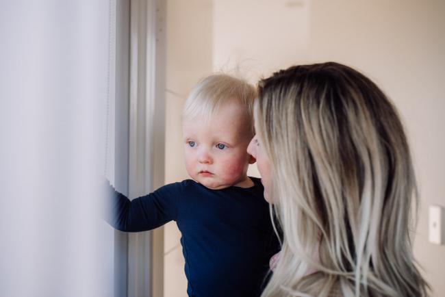 20180708-DSC_7715 mother holding her son as they look out the window during an in-home family photography Perth session