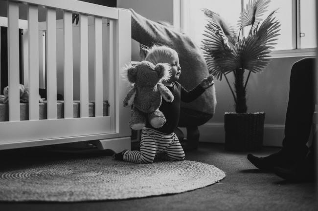 20180708-DSC_7982 black and white image of a little boy in his nursery on his knees and holding his teddy during an in-home family photography Perth session