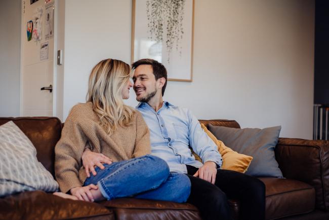 20180708-DSC_8187 couple sitting on the couch looking at each other during an in-home family photography Perth session
