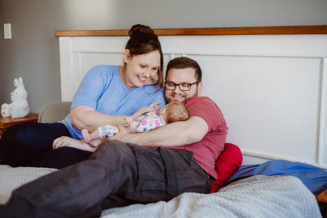 20180720-DSC_9136 mother and father holding their new baby on their bed during lifestyle newborn photography Perth session