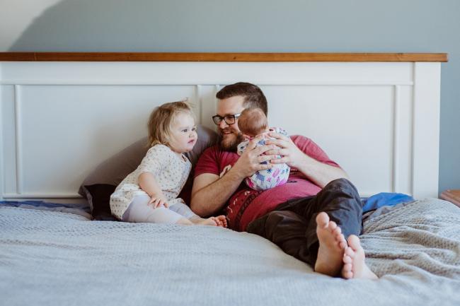 20180720-DSC_9183 Father laying on the bed with his two daughters during lifestyle newborn photography Perth session