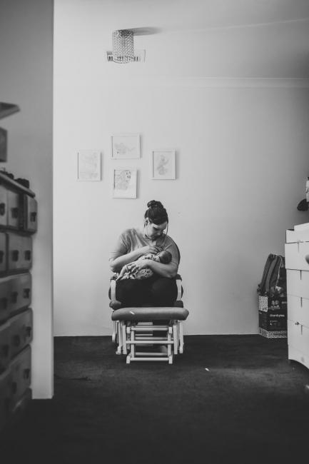 20180720-DSC_9292 black and white image of mother breastfeeding her new baby on a chair during lifestyle newborn photography Perth session