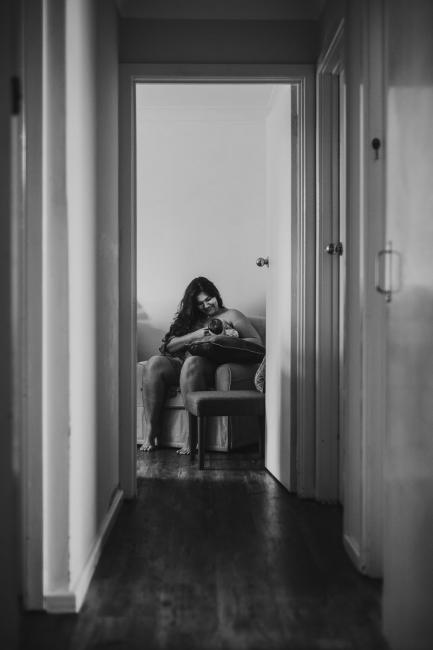 black and white image of mother breastfeeding her new baby during lifestyle family photography Perth session