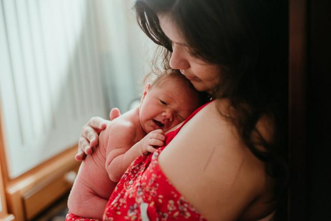 New baby being held on mothers chest during lifestyle family photography Perth session