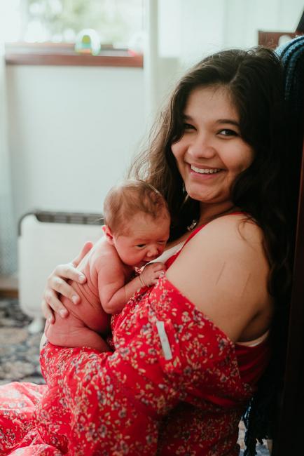 Naked new baby laying on mothers chest during lifestyle family photography Perth session