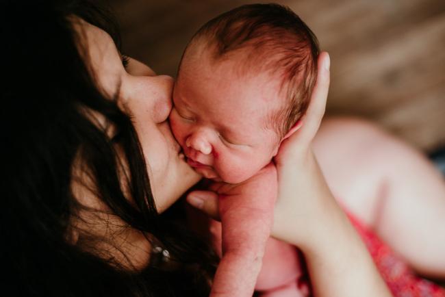 mother kissing new baby during lifestyle family photography Perth session