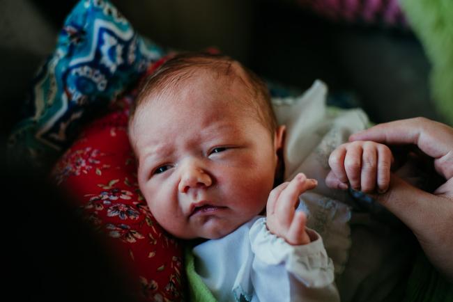 new baby looking up at mother and frowning during lifestyle family photography Perth session
