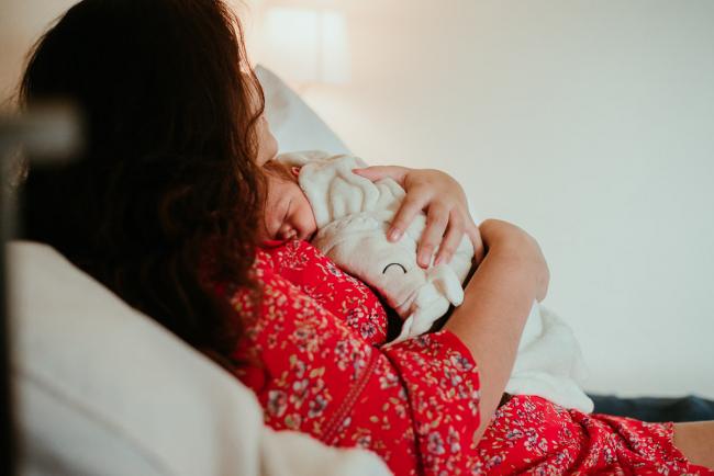 mother holding her wrapped baby on her chest during lifestyle family photography Perth session