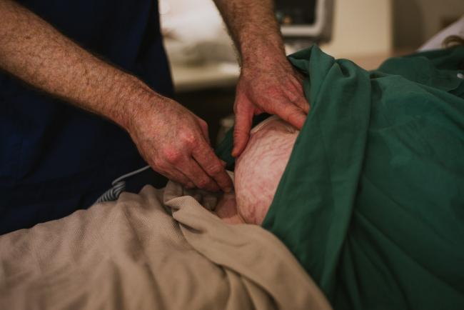 Midwife checking baby heartbeat with a doppler during Perth birth photography session