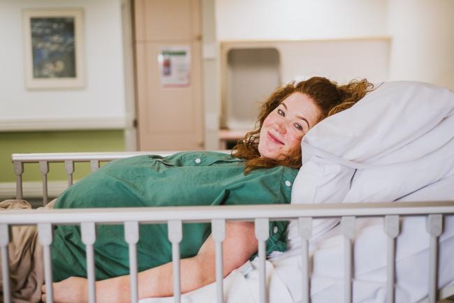 Pregnant woman in hospital bed during Perth birth photography session