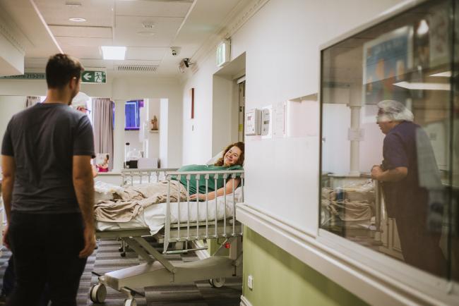 pregnant woman being wheeled around the corner during Perth birth photography session