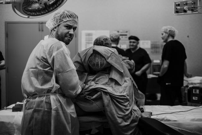 black and white image of pregnant mother being given an epidural during Perth birth photography session