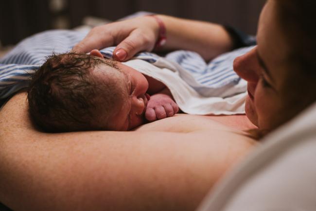 mother smiling and looking at her new baby during Perth birth photography session