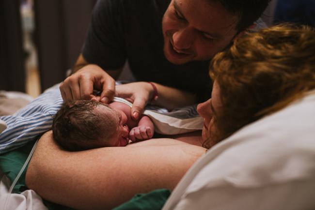 Parents smiling at their new baby during Perth birth photography session