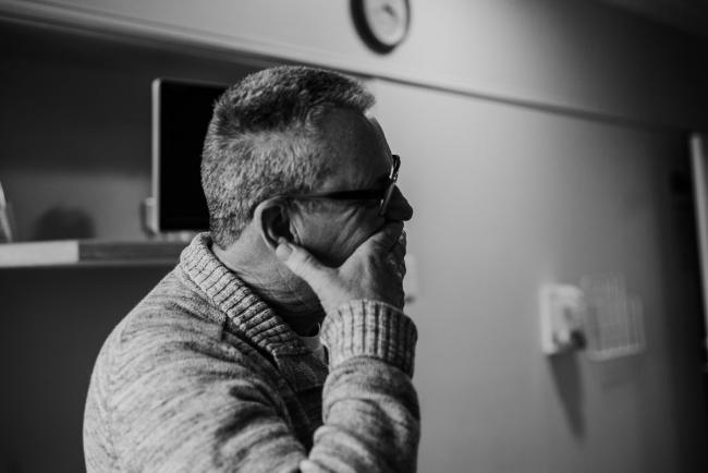 Black and white image of granfather looking towards his new grandchild during Perth birth photography session