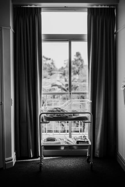 20180809-DSC_6334 black and white image of new baby in bassinet by hospital room window during Fresh 48 photography Perth session