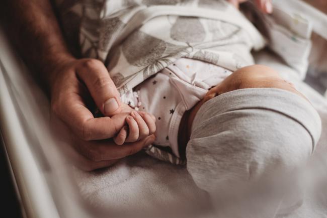 Close up of father holding new baby's hand during Fresh 48 Photography Perth session