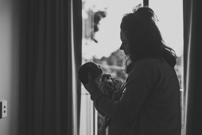 20180809-DSC_6548 black and white image of mother holding new baby in front of hospital window during Fresh 48 photography Perth session