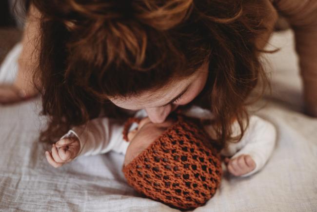 20180809-DSC_6900 mother kissing new baby with bonnet during Fresh 48 photography Perth session