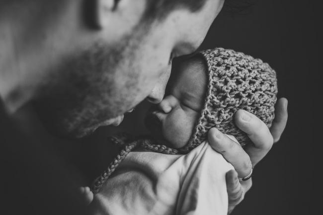 Black and white image of father holding his new baby so they are touching noses during Fresh 48 Photography Perth session