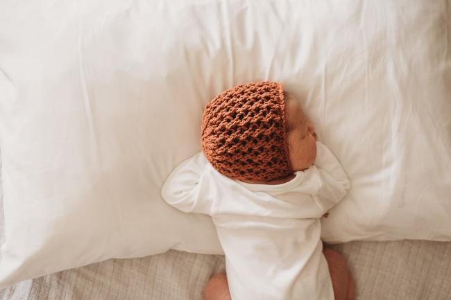 20180809-DSC_7288 baby with bonnet laying on white pillow during Fresh 48 photography Perth session