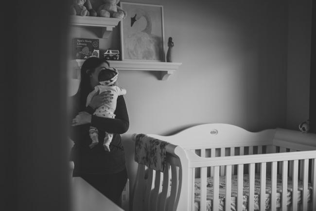 Black and white image of a mother holding her baby in the nursery during a Perth newborn photography session