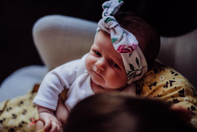 New baby looking up at her big sister during a Perth newborn photography session