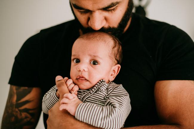 New baby holding onto his dad's thumb during a Perth newborn photography session