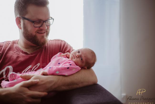 Dad holding his new baby in his arms during a newborn photography session in Perth