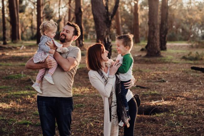 Dad holding his daughter and mum holding her son during a family photography session at The Pines Wanneroo in Perth