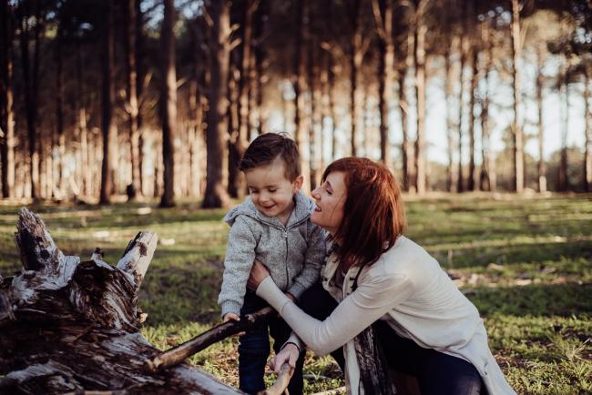 20180901-DSC_0084 Mother cuddling son while son is playing with a stick during family photography Perth session at The Pines Wanneroo