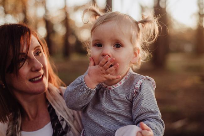 20180901-DSC_1474 mother holding daughter while daughter blows a kiss during family photography Perth session at The Pines Wanneroo