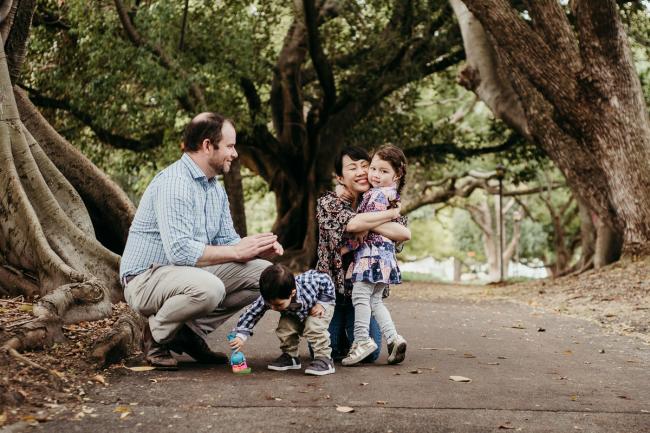 20180908-DSC_2051-1 Father squatting on the ground while son plays with bubbles and mother and daughter hug during extended family photography Perth session at Hyde Park
