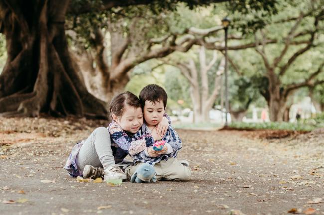 20180908-DSC_2396-1 Little girl cuddling her younger brother as they sit on the path during extended family photography Perth session at Hyde Park