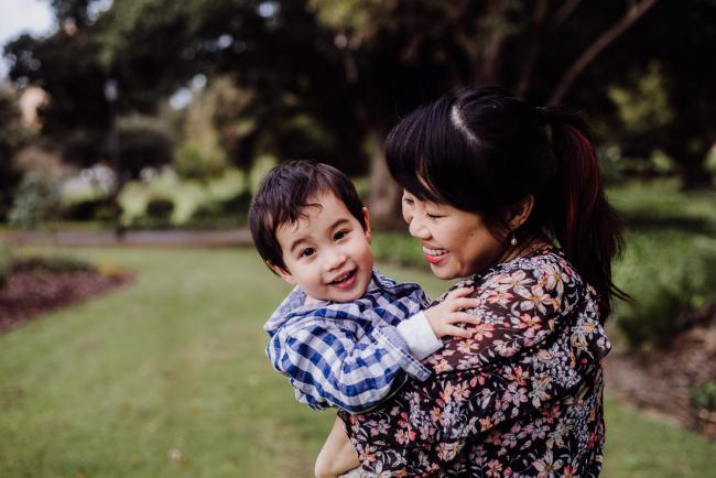 20180908-DSC_2659 mother holding her son and smiling at him as he smiles at the camera during extended family photography Perth session at Hyde Park